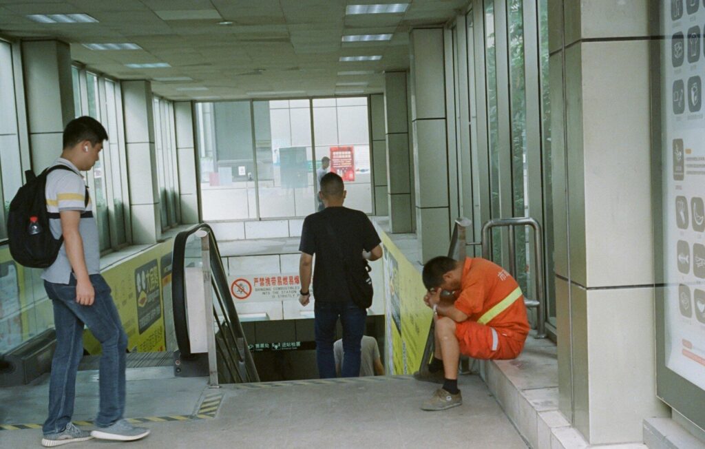 a group of men standing next to each other near an escalator